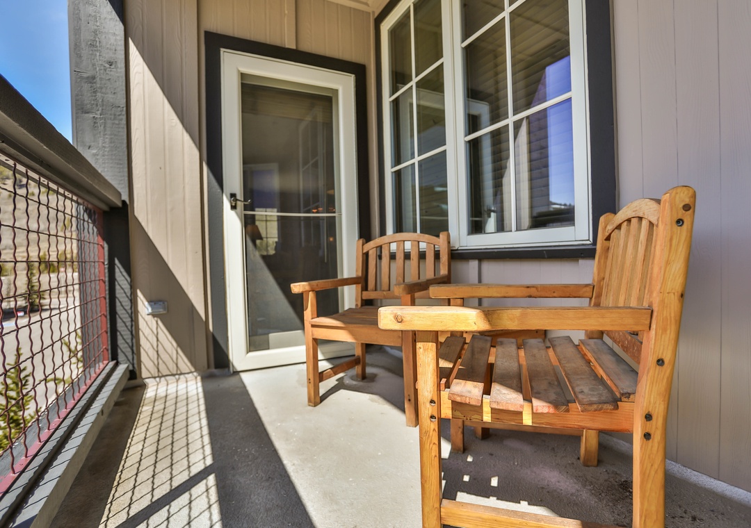 Your private balcony beckons with cozy wooden chairs and a small table, perfect for morning coffee or evening relaxation.