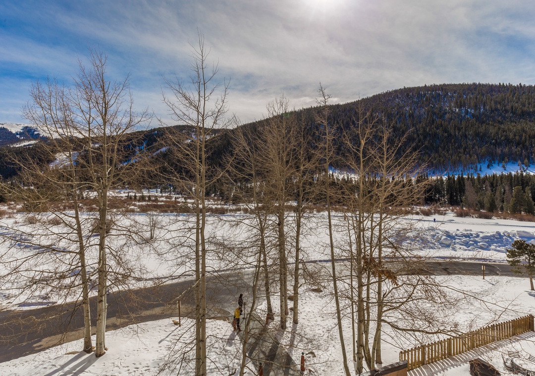 Winter mountain valley with snow-covered hills and forest-lined slopes creating a picturesque alpine setting.