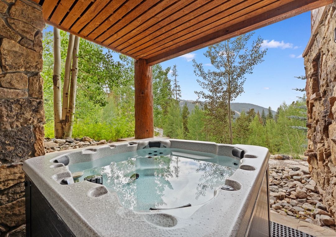 Soak in your private hot tub surrounded by natural stone walls while taking in breathtaking mountain views.