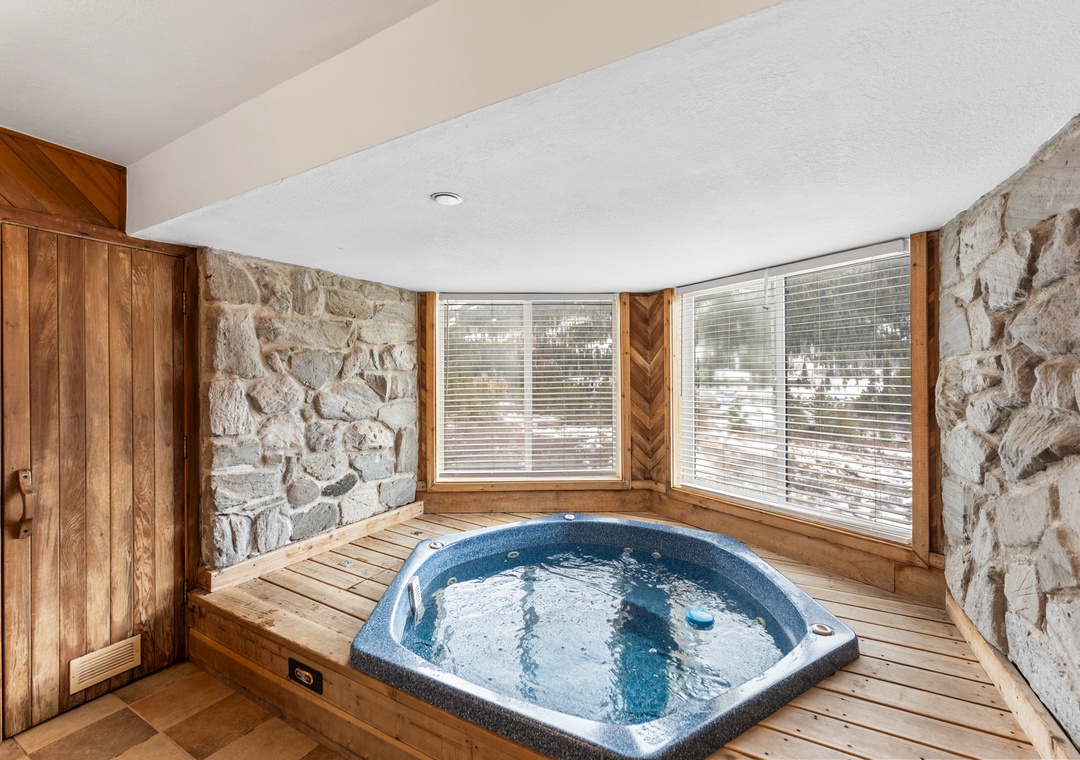 Slip into your private hot tub sanctuary, where stone walls and warm wood create the perfect alpine spa escape.