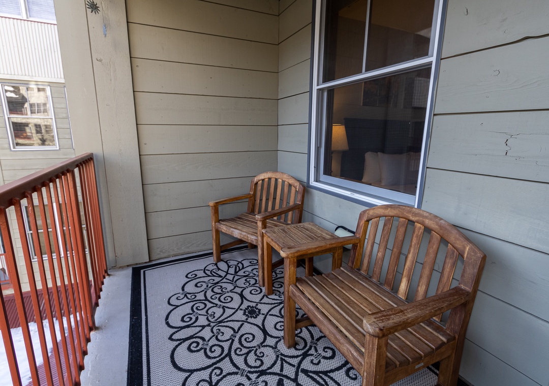 Your private balcony offers cozy wooden seating where you can sip morning coffee or unwind with evening views.