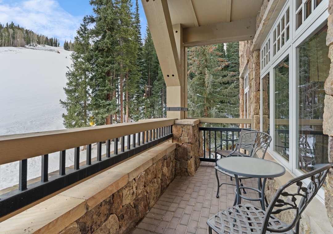 Relax on your private balcony with mountain views, where morning coffee feels perfect surrounded by snow-dusted pines and peaceful alpine scenery.