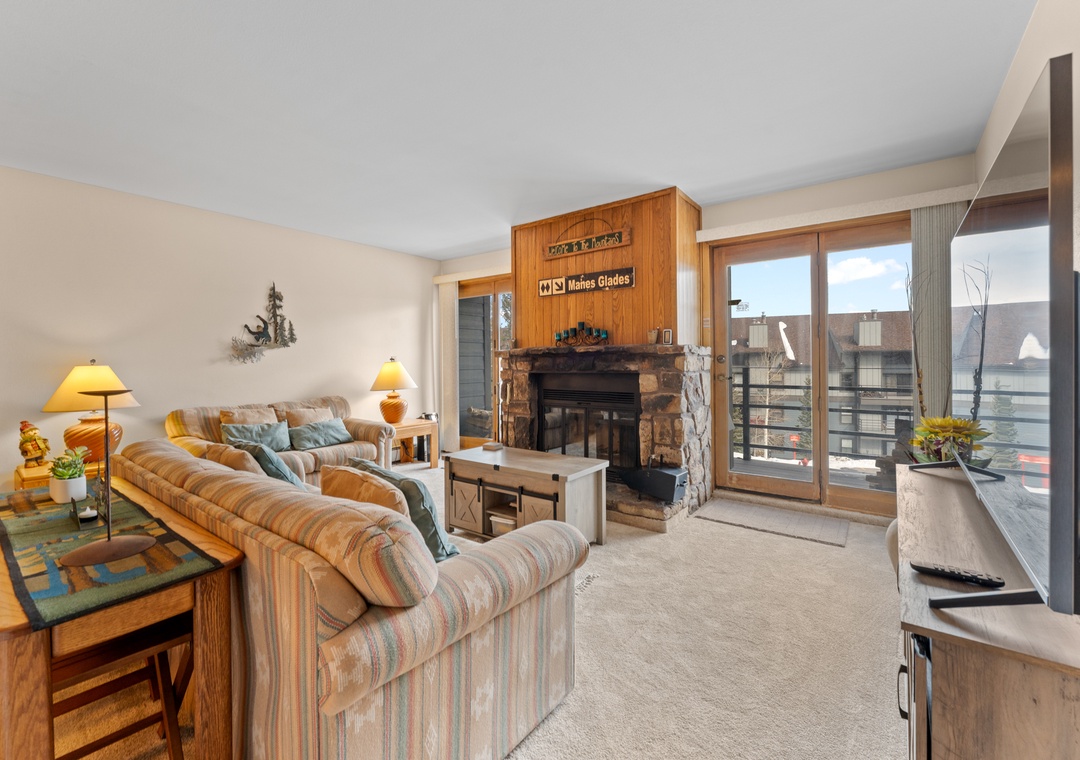Relax in your cozy living room with a warming fireplace and mountain views through expansive windows.