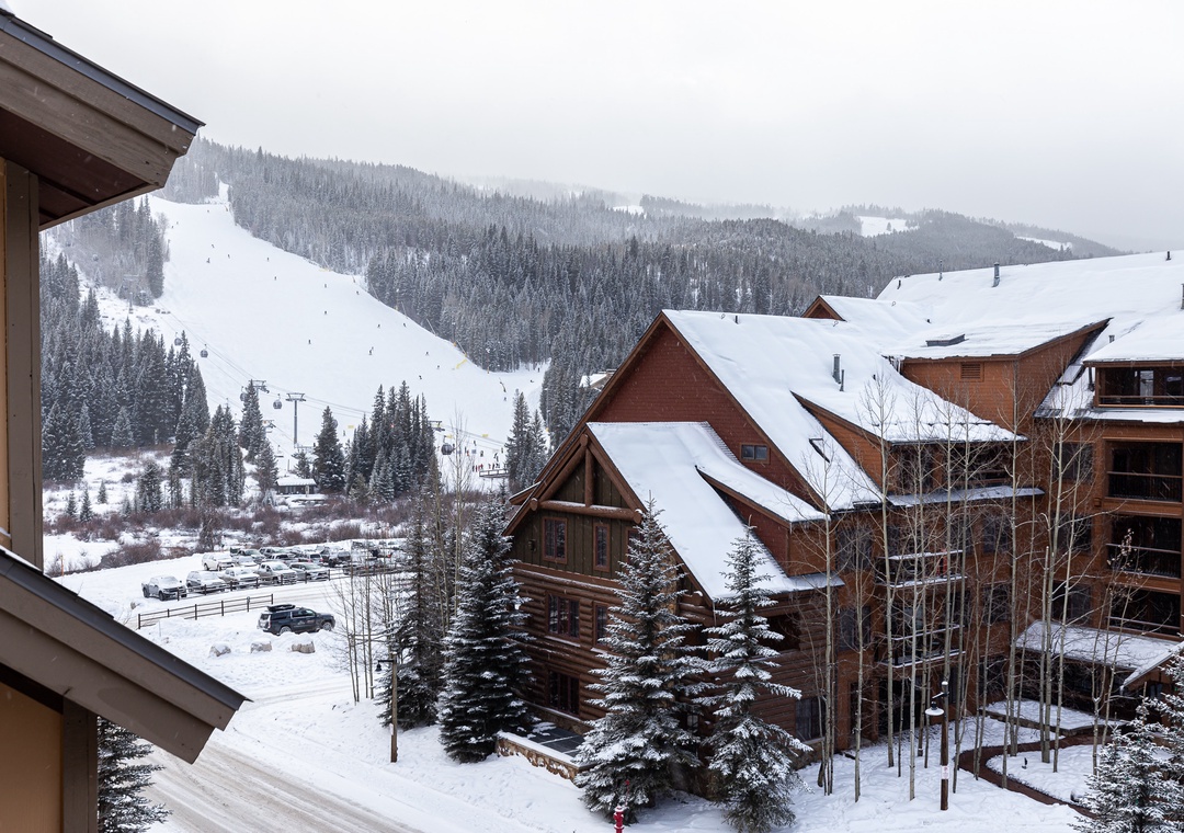 Snow-covered alpine village with ski slopes and mountain chalets during winter season.