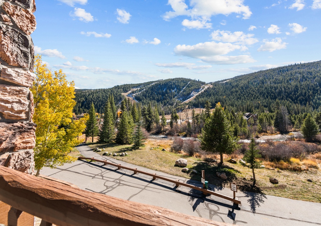Mountain valley vista with ski slopes and autumn foliage visible from this elevated outdoor vantage point.