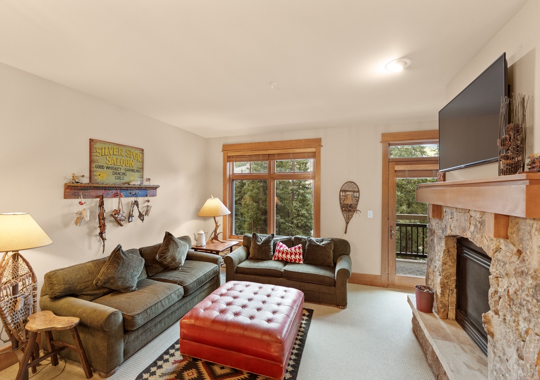 Sink into plush sofas by your stone fireplace, where warm lighting and mountain views create the perfect retreat after adventurous days.