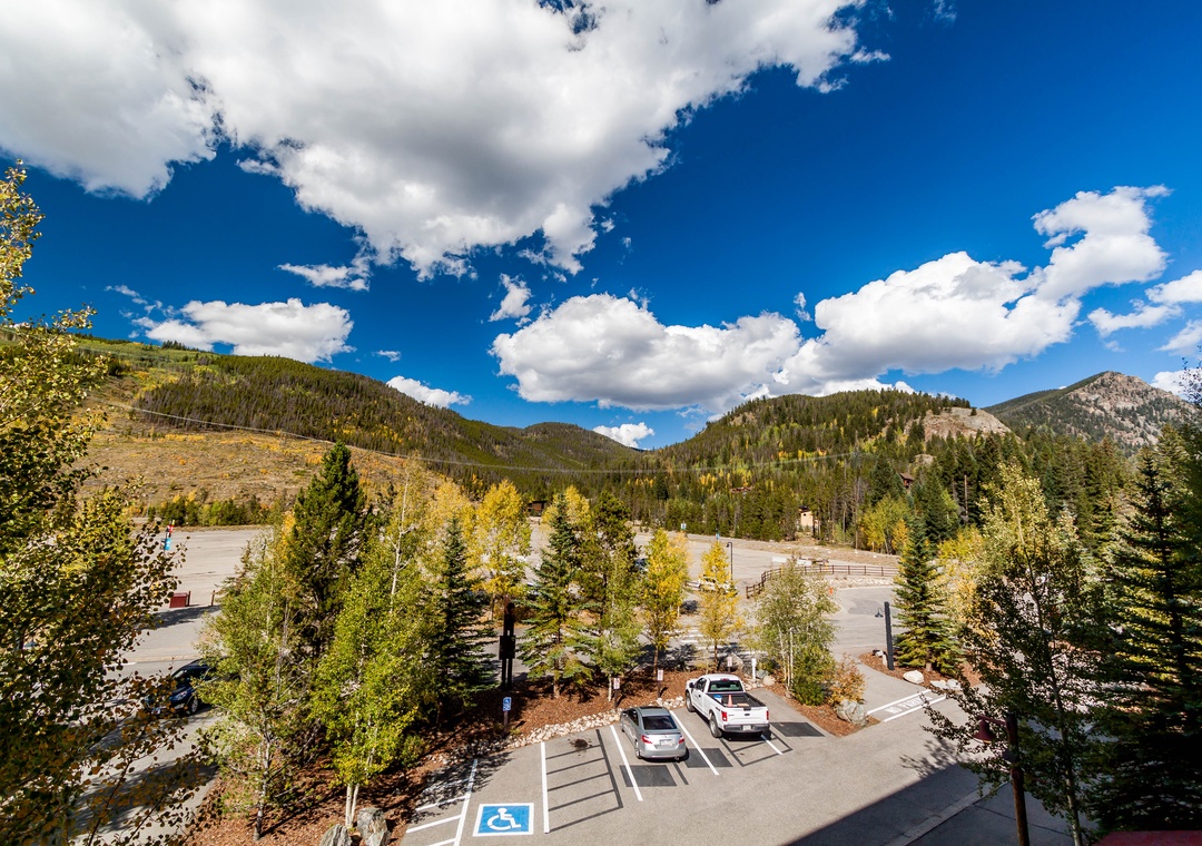 Scenic mountain valley setting with forested peaks and convenient parking facilities for exploring the natural surroundings.