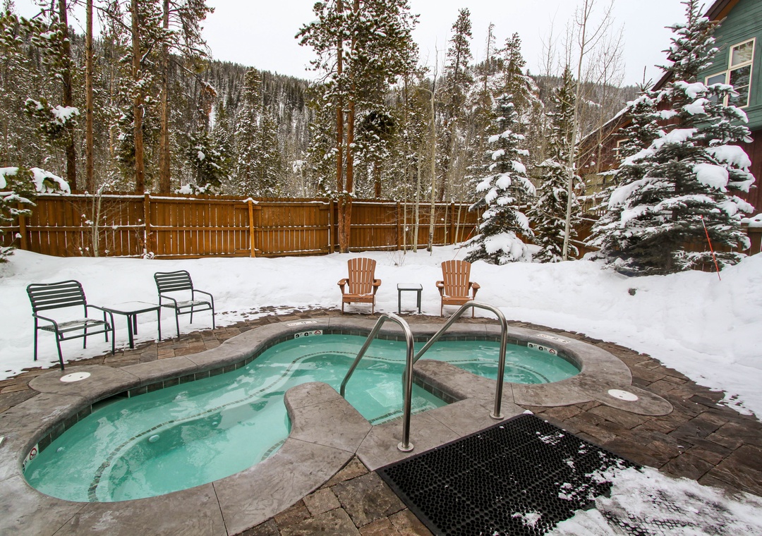 Soak away winter's chill in your private hot tub, surrounded by snow-dusted pines and mountain serenity.