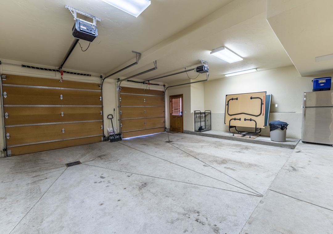 Spacious garage with convenient parking and storage for your gear, featuring folded ping pong table for entertainment.