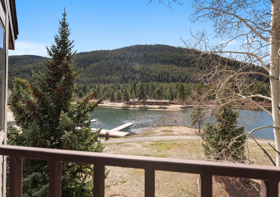 Lake and mountain views from your balcony, overlooking Keystone Lake, its docks, and a forested mountain backdrop.