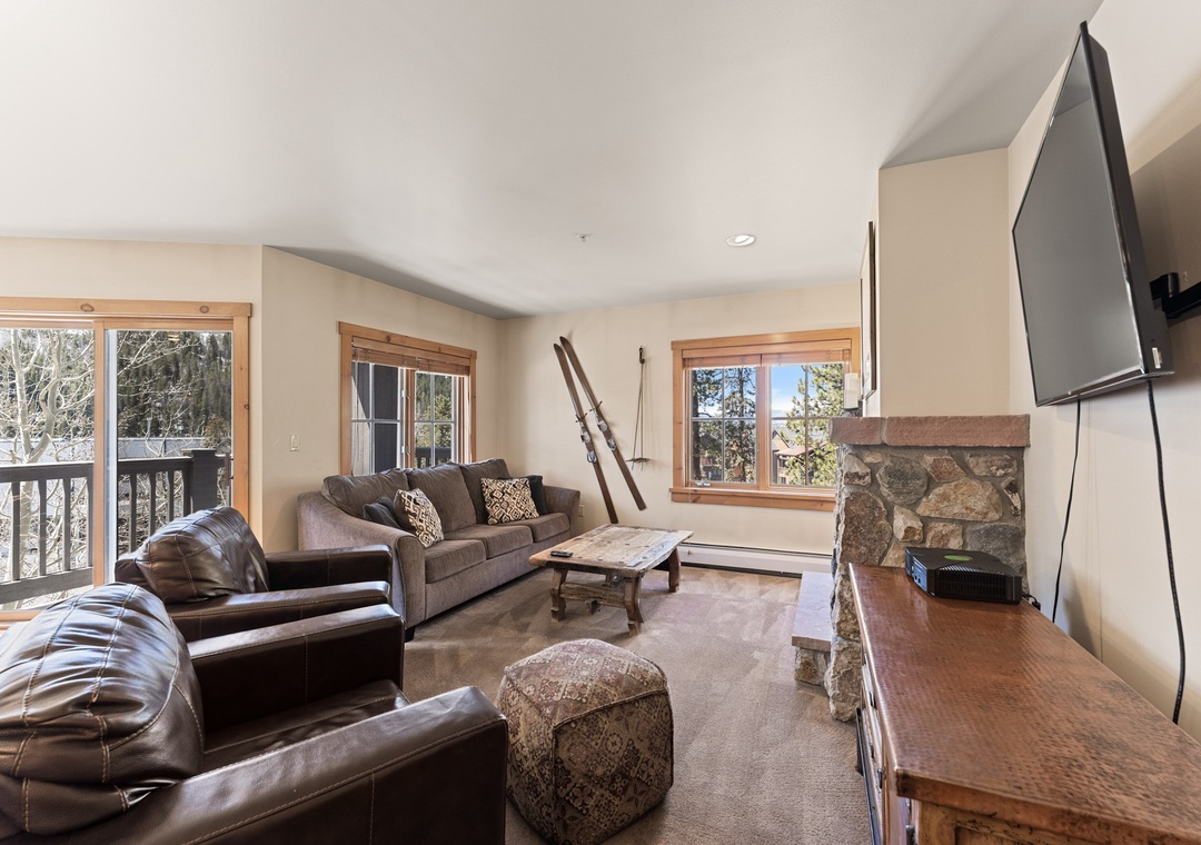 Curl up in your cozy living room with leather seating, stone fireplace, and mountain views through large windows.