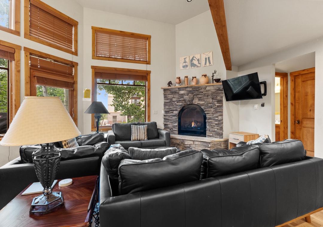 Gather around the crackling stone fireplace in this inviting living space, where plush leather seating and warm wood details create your perfect mountain retreat.