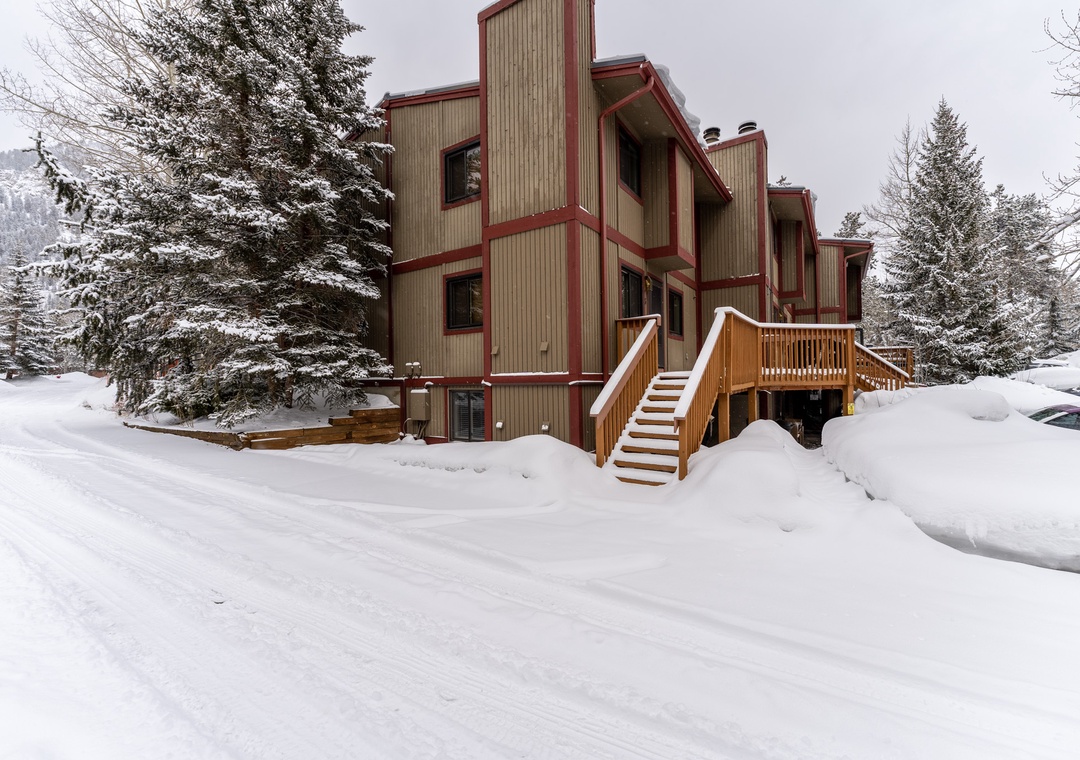 Mountain retreat nestled in pristine winter wonderland, surrounded by snow-covered evergreens and peaceful alpine scenery.