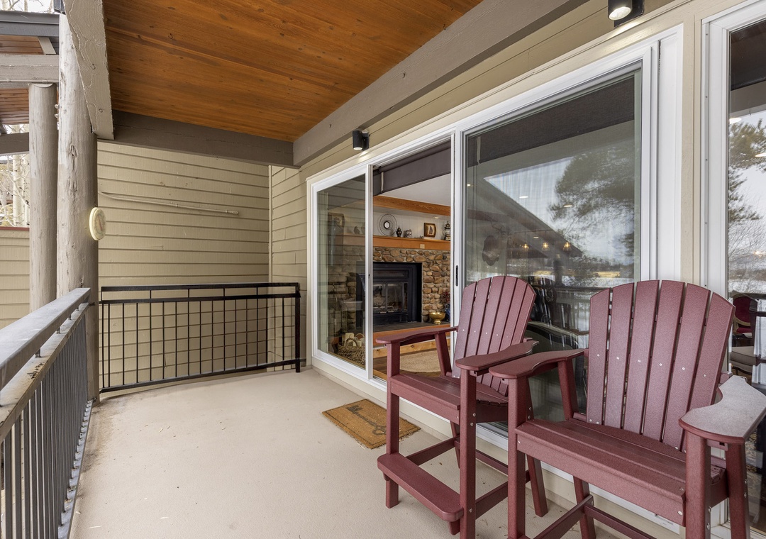 Step onto your private covered balcony with cozy Adirondack chairs, perfect for morning coffee while enjoying peaceful views through the trees.