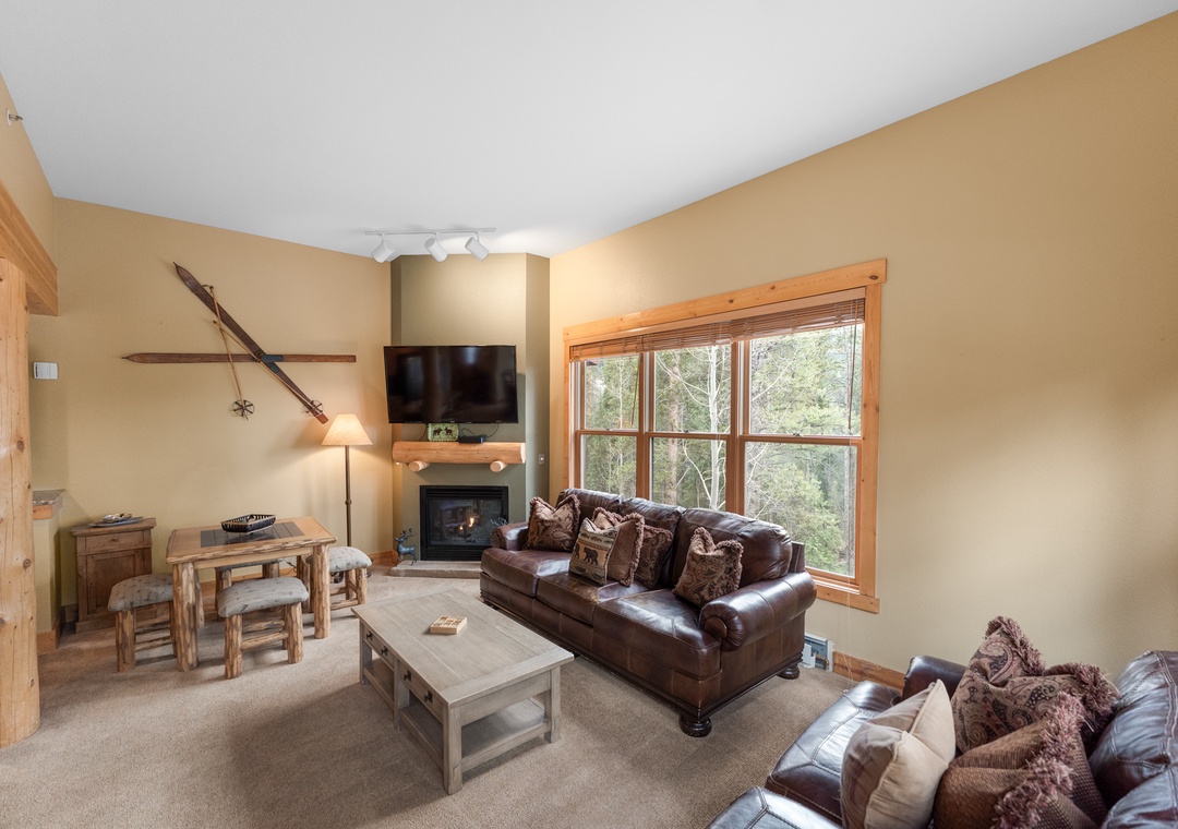 Curl up with loved ones in your cozy living room, where rustic charm meets comfort with leather sofas and a crackling fireplace.