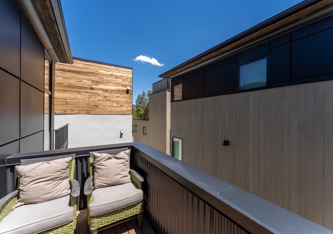 Relax on your private balcony with comfortable seating, soaking up sunshine while enjoying peaceful views of the contemporary neighborhood.