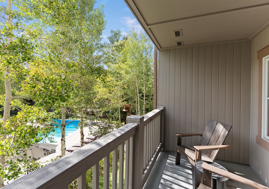 Relax in your private outdoor sanctuary, where an Adirondack chair invites you to soak up the sun and enjoy peaceful views of the sparkling pool and leafy surroundings.