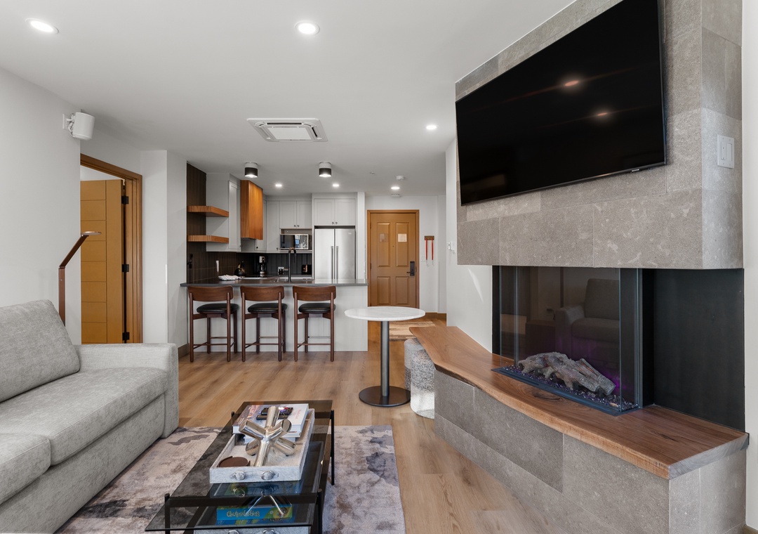 Unwind by your modern fireplace while enjoying the open kitchen and stylish living area designed for your comfort.