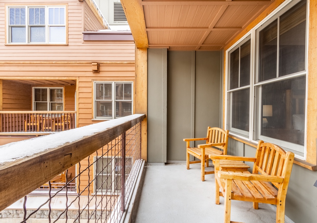 Step onto your private screened balcony with comfortable teak seating, perfect for morning coffee while enjoying peaceful courtyard views.