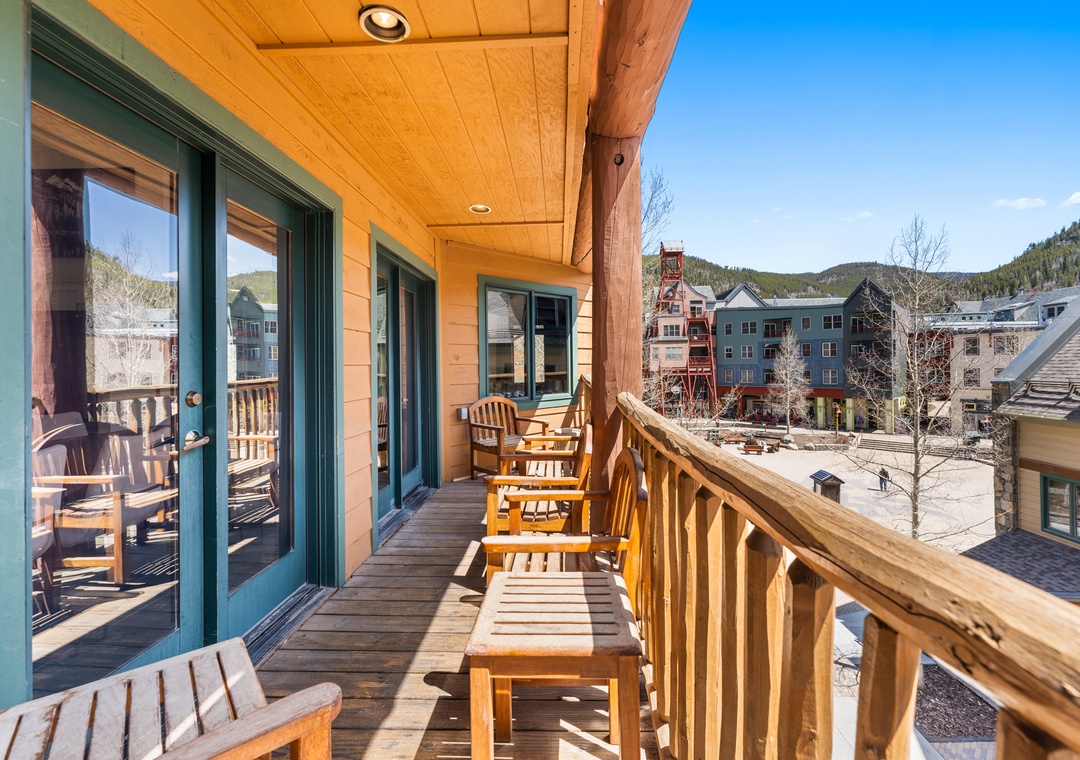 Relax on your private balcony with wooden chairs, soaking up mountain sunshine while overlooking the charming village below.
