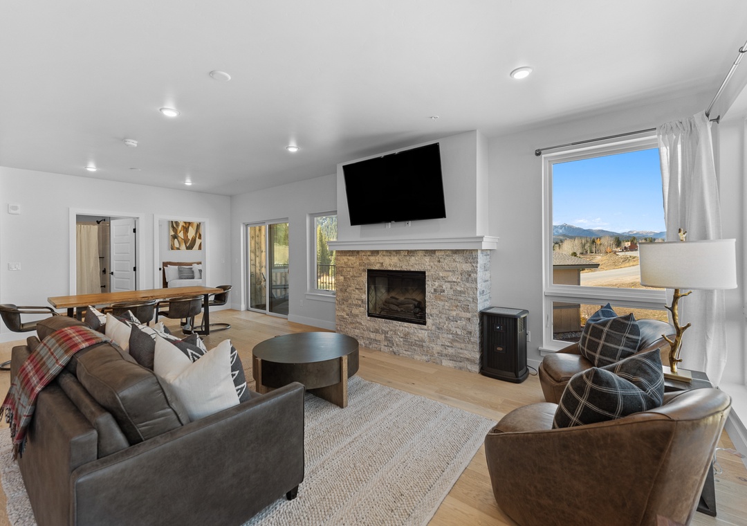 Unwind in your spacious living room with stone fireplace, mountain views, and cozy seating perfect for memorable evenings together.
