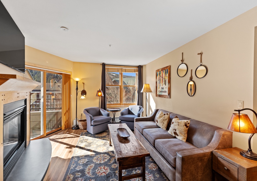 Unwind in your cozy living room with warm fireside seating, mountain views, and rustic Colorado charm welcoming you home.