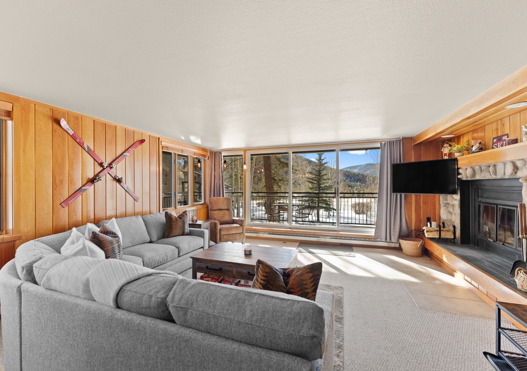 Unwind in your spacious mountain retreat with plush seating, crackling fireplace, and stunning ski slope views through panoramic windows.
