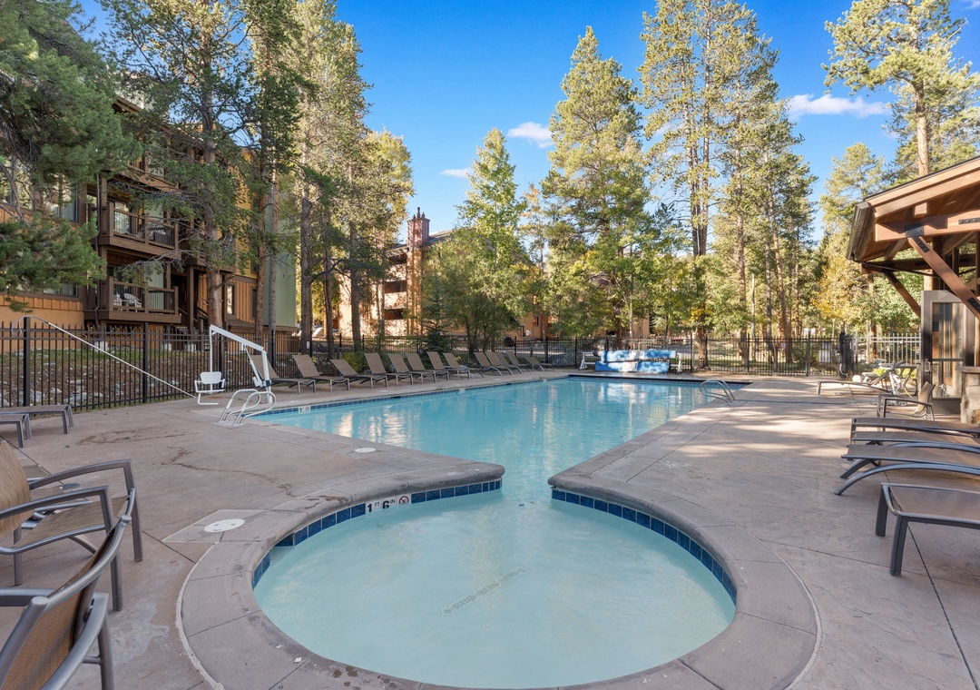 The property features an inviting outdoor pool surrounded by towering pines and mountain air, offering a peaceful spot to unwind after exploring the area.