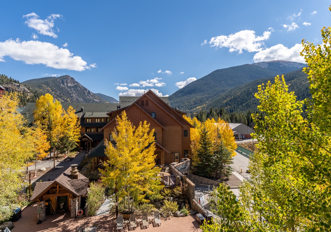 Mountain resort property nestled among golden autumn aspens with dramatic peaks creating a stunning alpine backdrop for your stay.