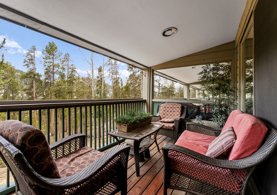 Step onto your private balcony where forest views and comfortable wicker seating create the perfect spot for morning coffee or evening relaxation.