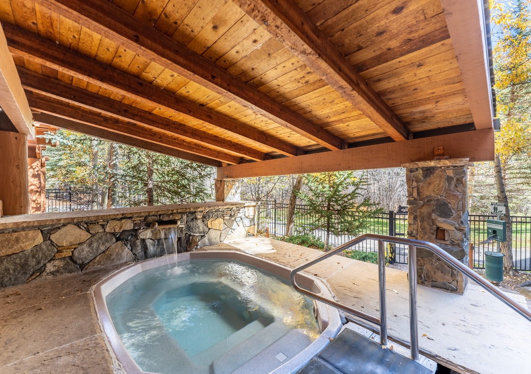 Slip into your private hot tub beneath rustic wooden beams, where warm bubbling waters and stone accents create your perfect mountain retreat.