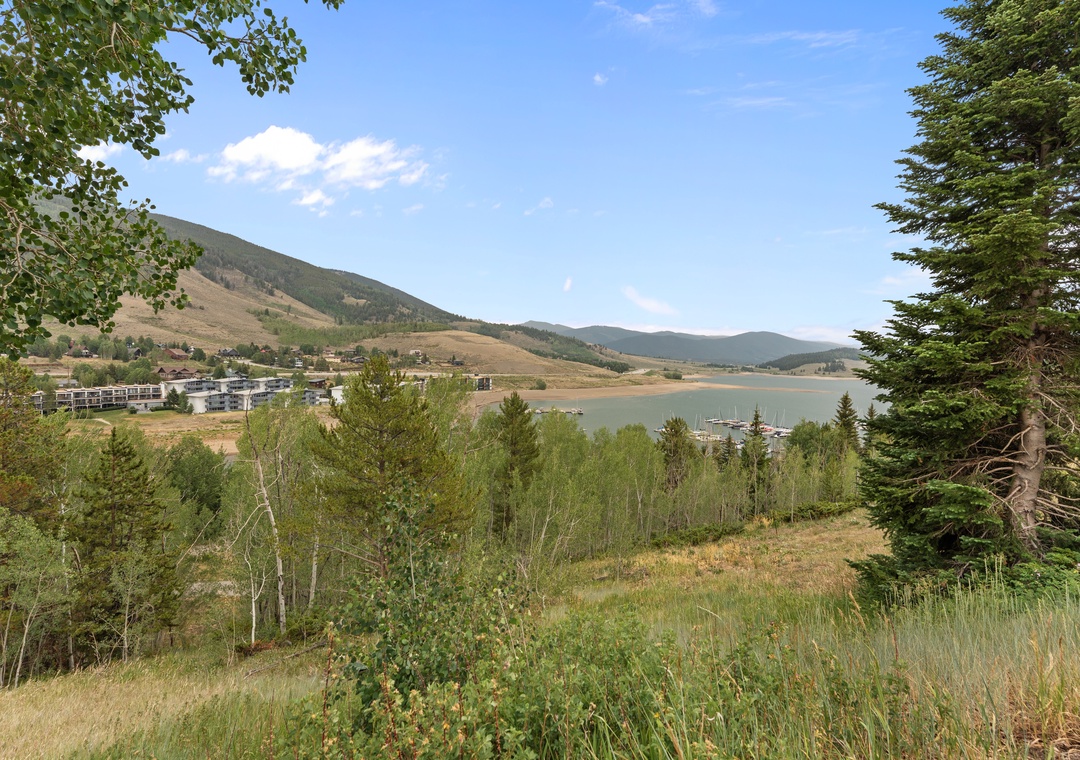 A panoramic lakeside setting framed by rolling mountains and evergreen forests marks the property's scenic surroundings and nearby recreational area.