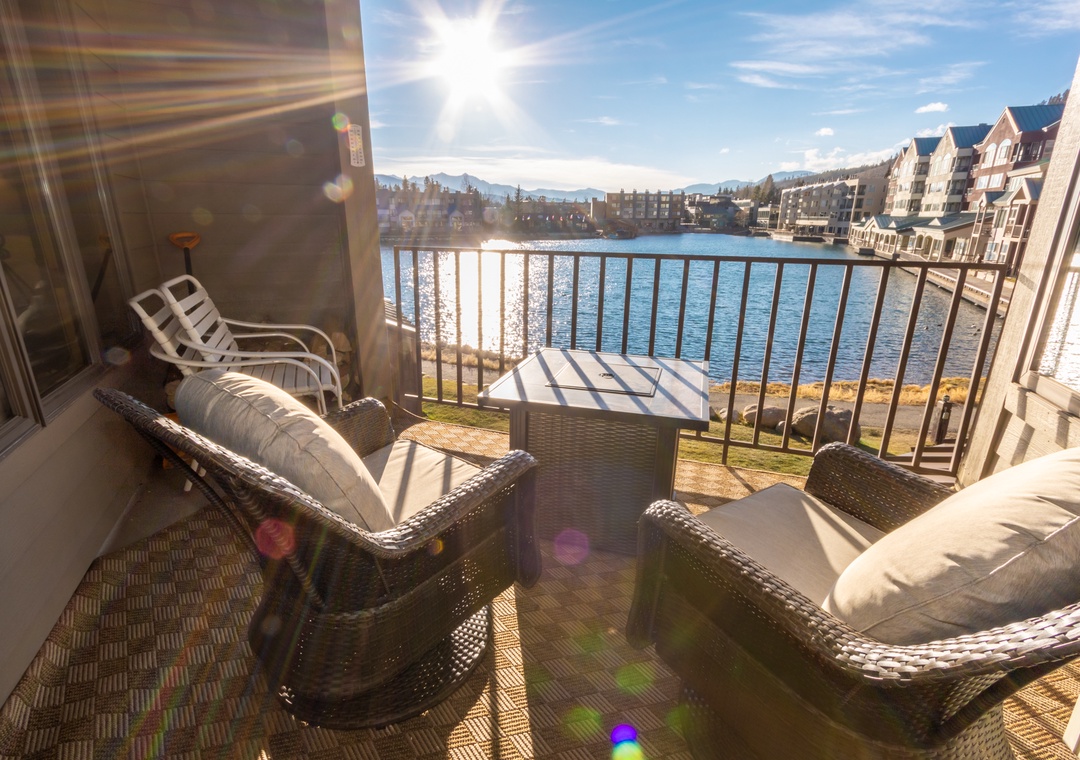 Sink into plush wicker seating on your private balcony where golden sunlight dances across the water and mountain views create the perfect backdrop for morning coffee.
