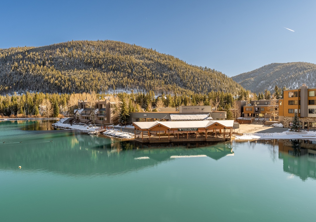 Stunning lakefront property surrounded by snow-capped mountains and pristine turquoise waters in a peaceful alpine setting.
