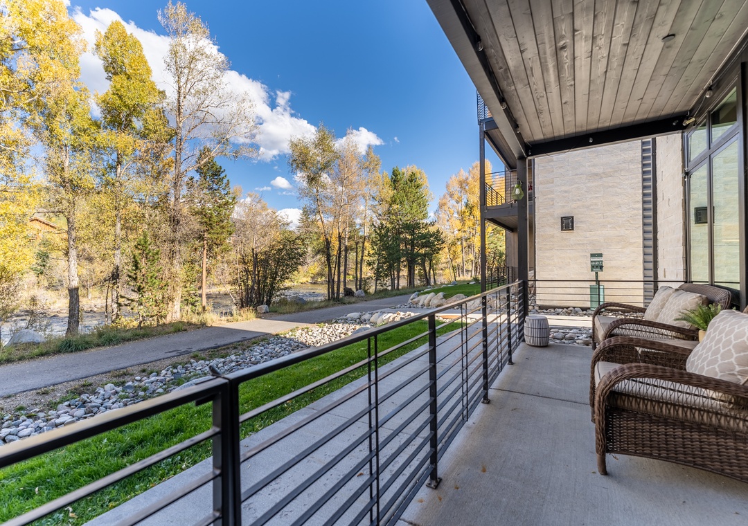 Step onto your private balcony and sink into comfortable wicker seating while taking in the peaceful water views through autumn trees.