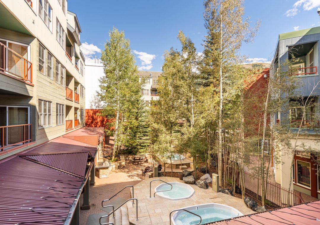 Relaxing hot tubs nestled among mature trees create your perfect outdoor retreat in this peaceful courtyard setting.