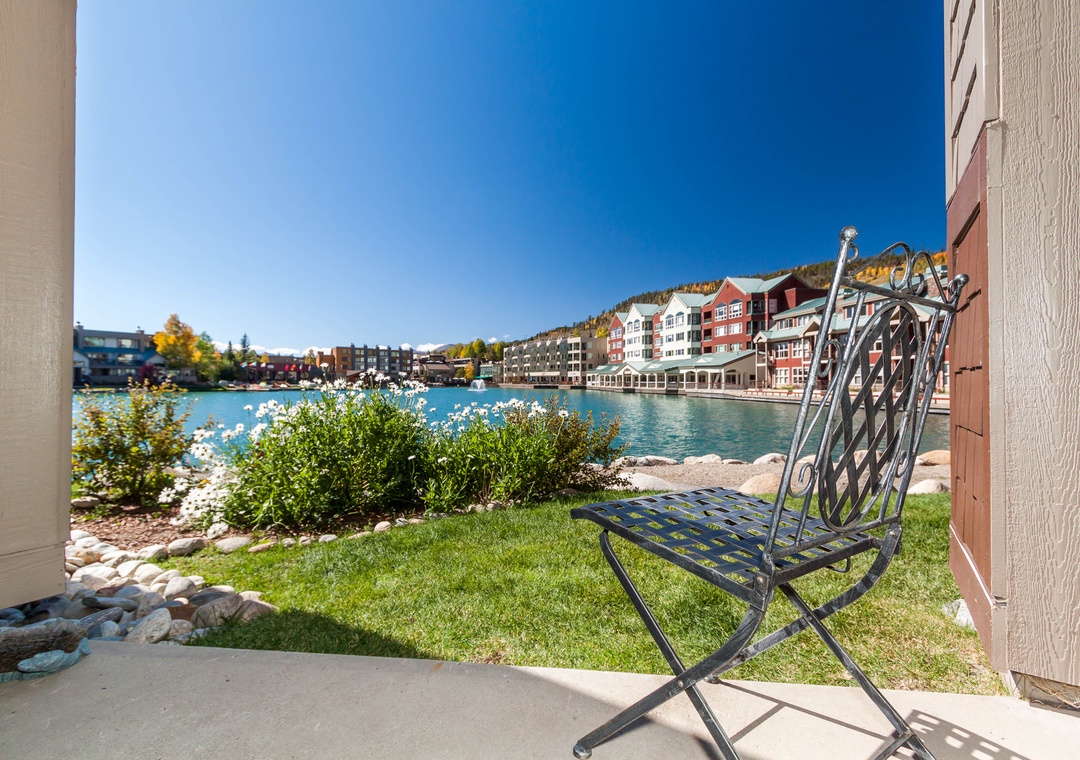 Step onto your private patio where a peaceful chair awaits, offering stunning lakefront views and manicured gardens for your perfect retreat.