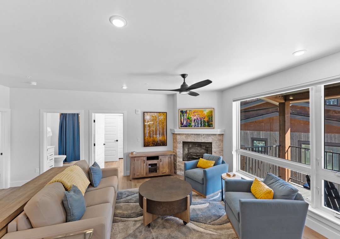 Relax in your bright, modern living room with cozy seating, warm fireplace, and large windows overlooking the peaceful neighborhood.