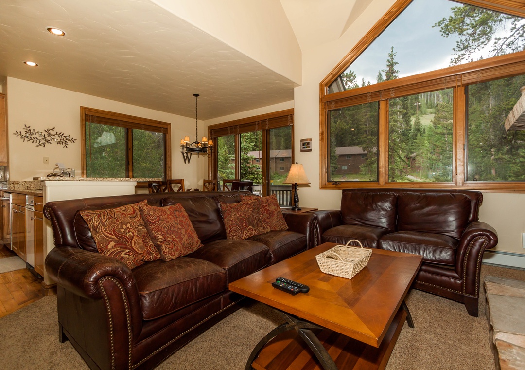 Sink into plush leather sofas while enjoying forest views through expansive windows in your mountain retreat.