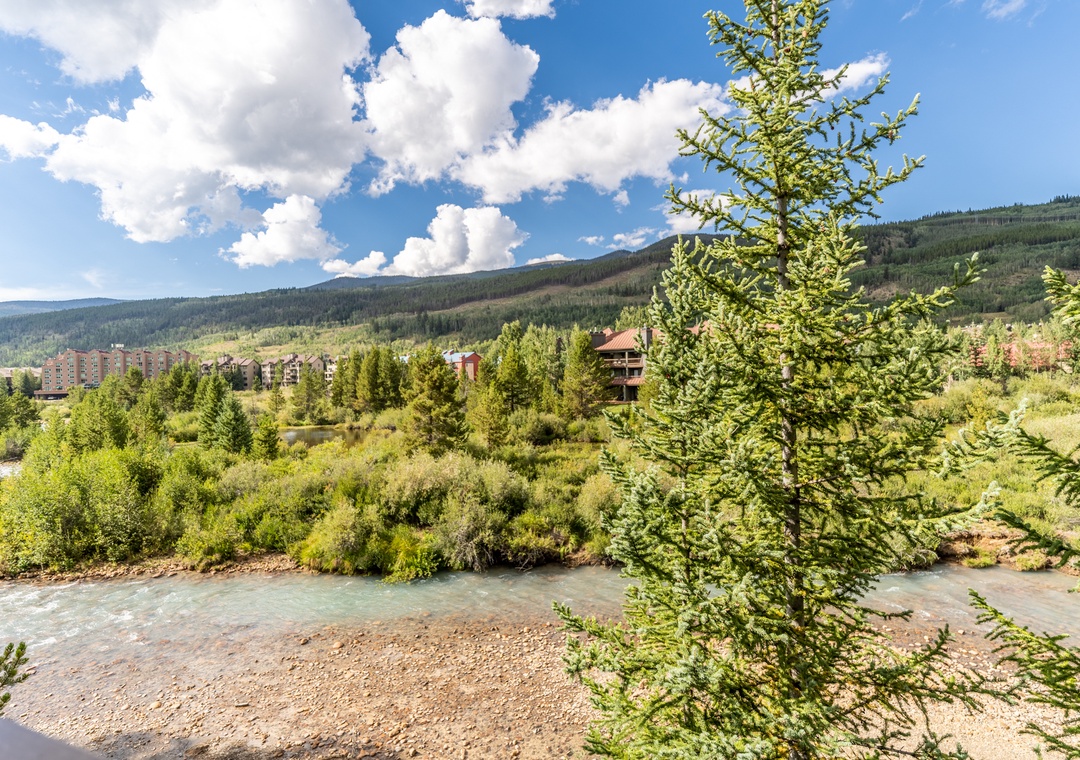 Mountain resort surrounded by pristine wilderness and flowing river, offering scenic natural beauty.