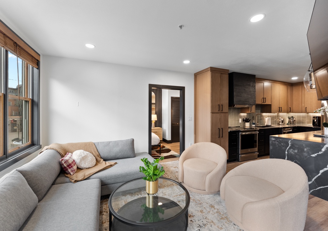 Unwind in your stylish living space with plush seating and modern kitchen, where city views frame your perfect urban retreat.
