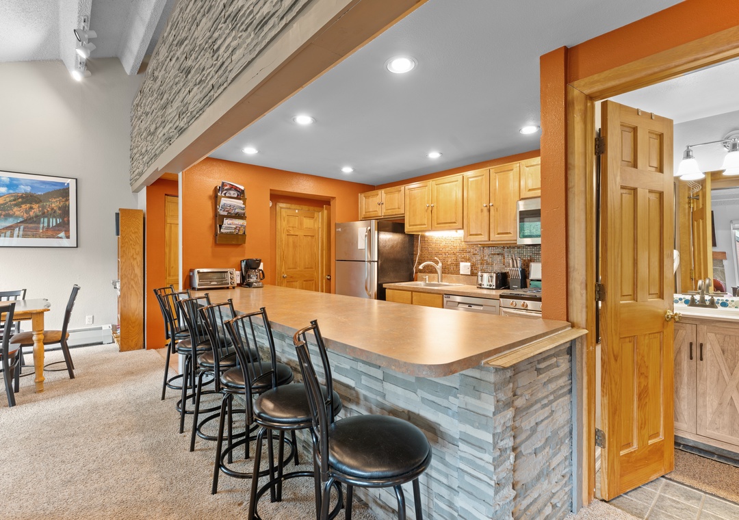 Gather around your spacious kitchen island with room for everyone, featuring sleek appliances and warm wood cabinetry. The open design flows seamlessly into your dining area, perfect for cooking together and sharing meals.