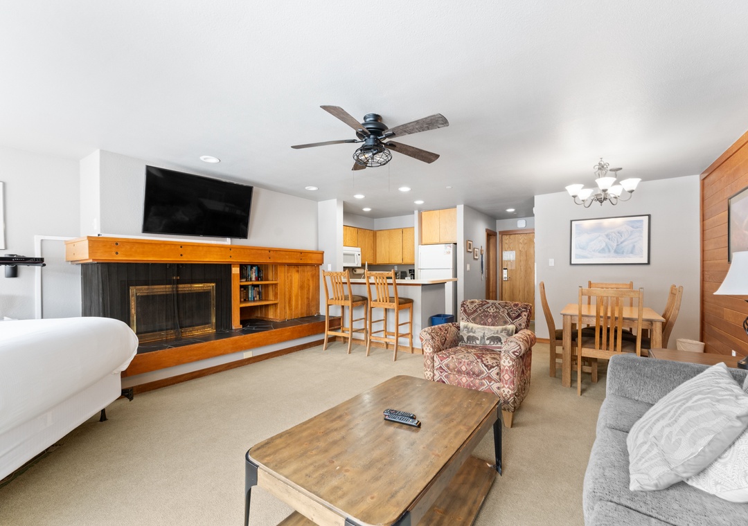 Relax in your spacious open-concept living area featuring a cozy fireplace, full kitchen, and comfortable seating for memorable evenings together.