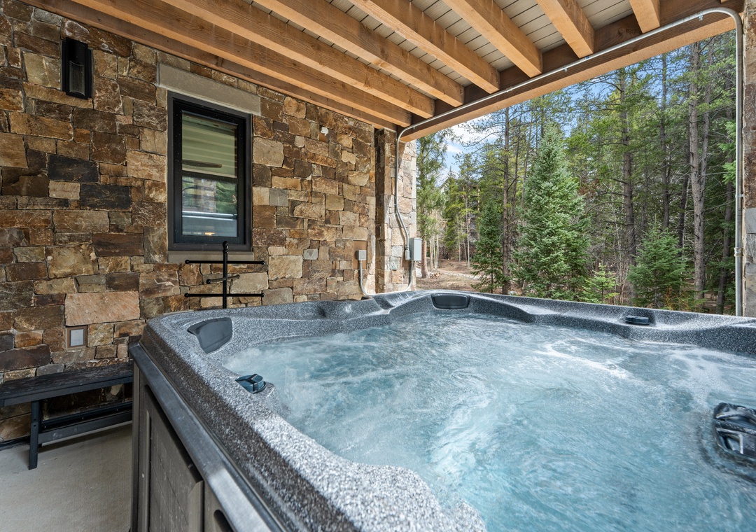 Soak in your private hot tub under the timber-beamed patio, surrounded by towering pines and the peaceful sounds of nature—your perfect mountain retreat.
