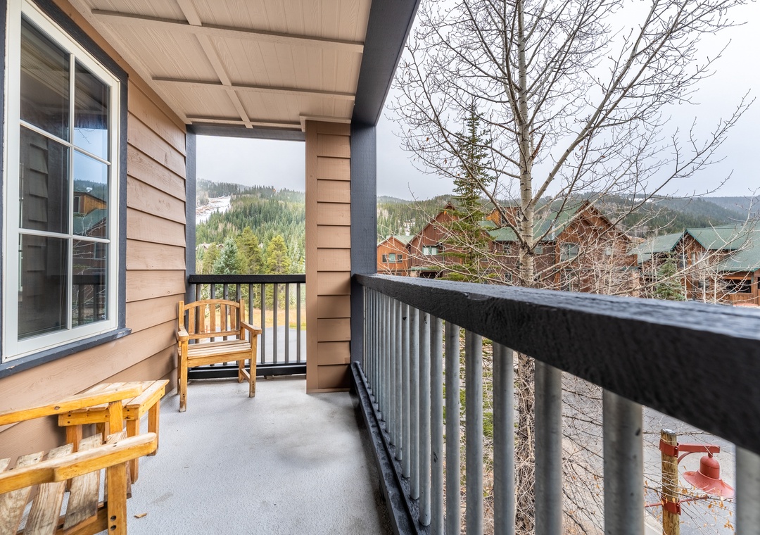 Step onto your private balcony with cozy seating and breathe in mountain views stretching across forested hillsides—your perfect morning coffee spot.