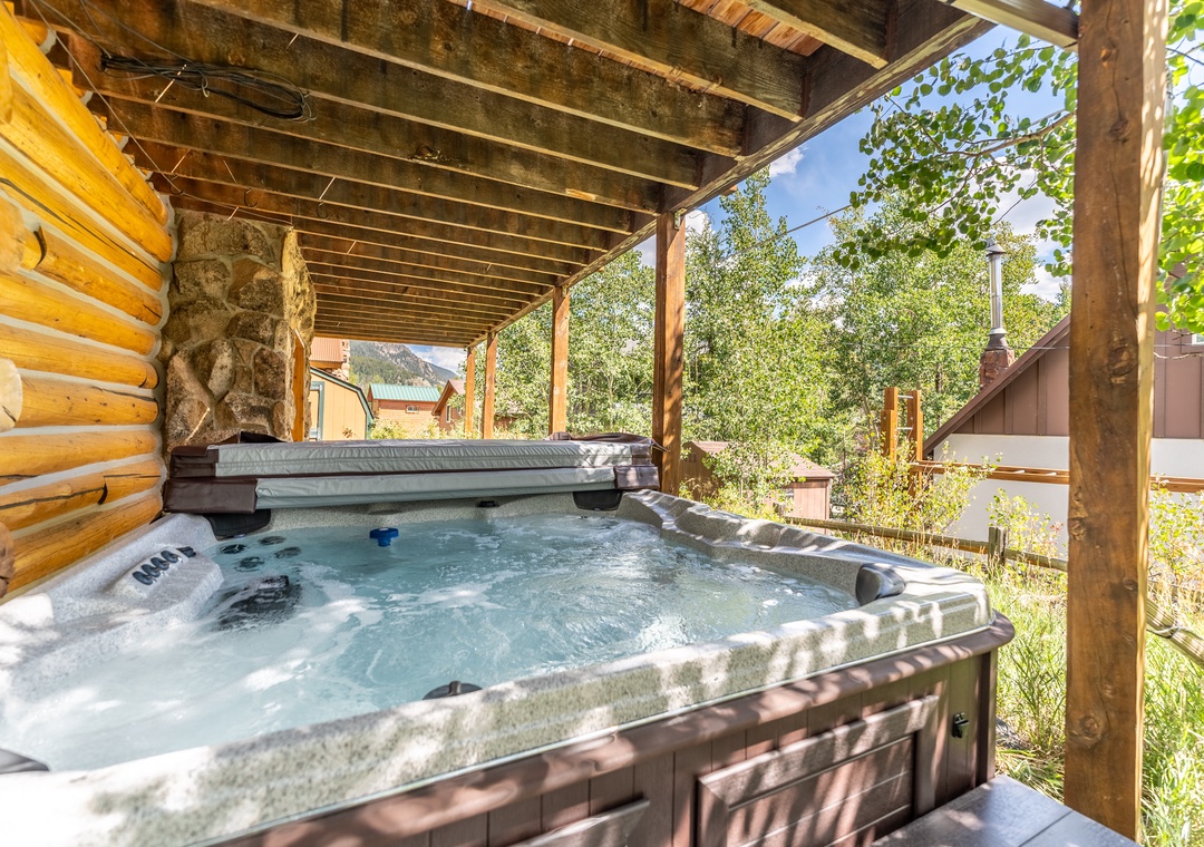 Soak your cares away in this private hot tub, nestled under rustic beams with mountain views beckoning beyond the trees.