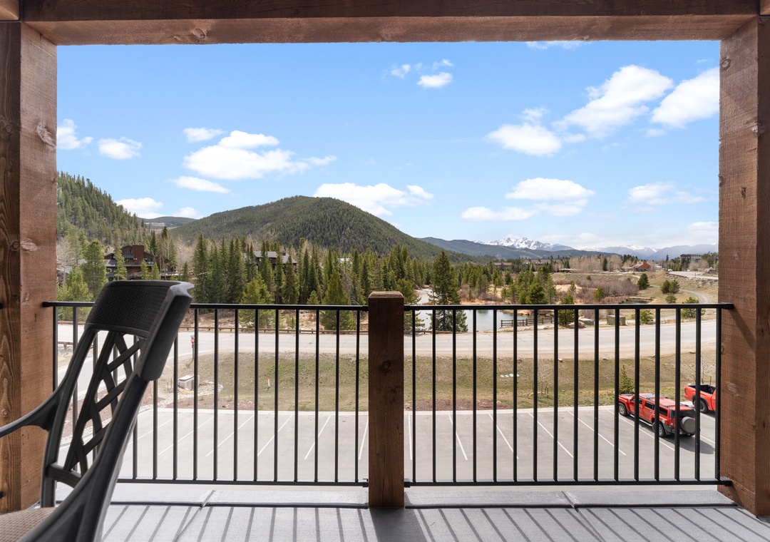 Framed by rustic timber posts, this mountain vista offers peaceful views of forested slopes, snow-dusted peaks, and the tranquil valley below—part of the scenic surroundings near the property.