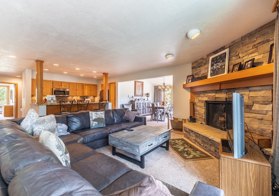 Cozy up by your stone fireplace in this warm living room, where leather seating and rustic charm create the perfect retreat.