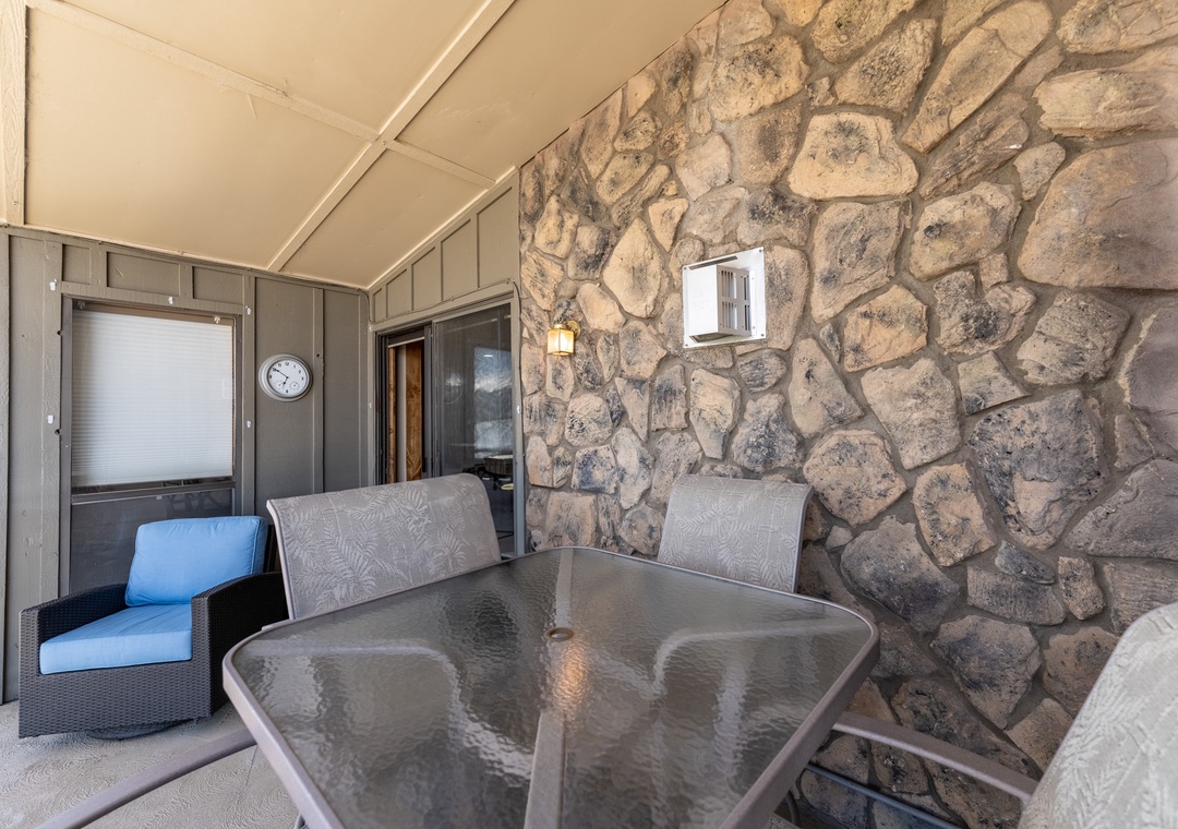 Relax on your private covered patio with rustic stone walls and comfortable seating for memorable evenings.