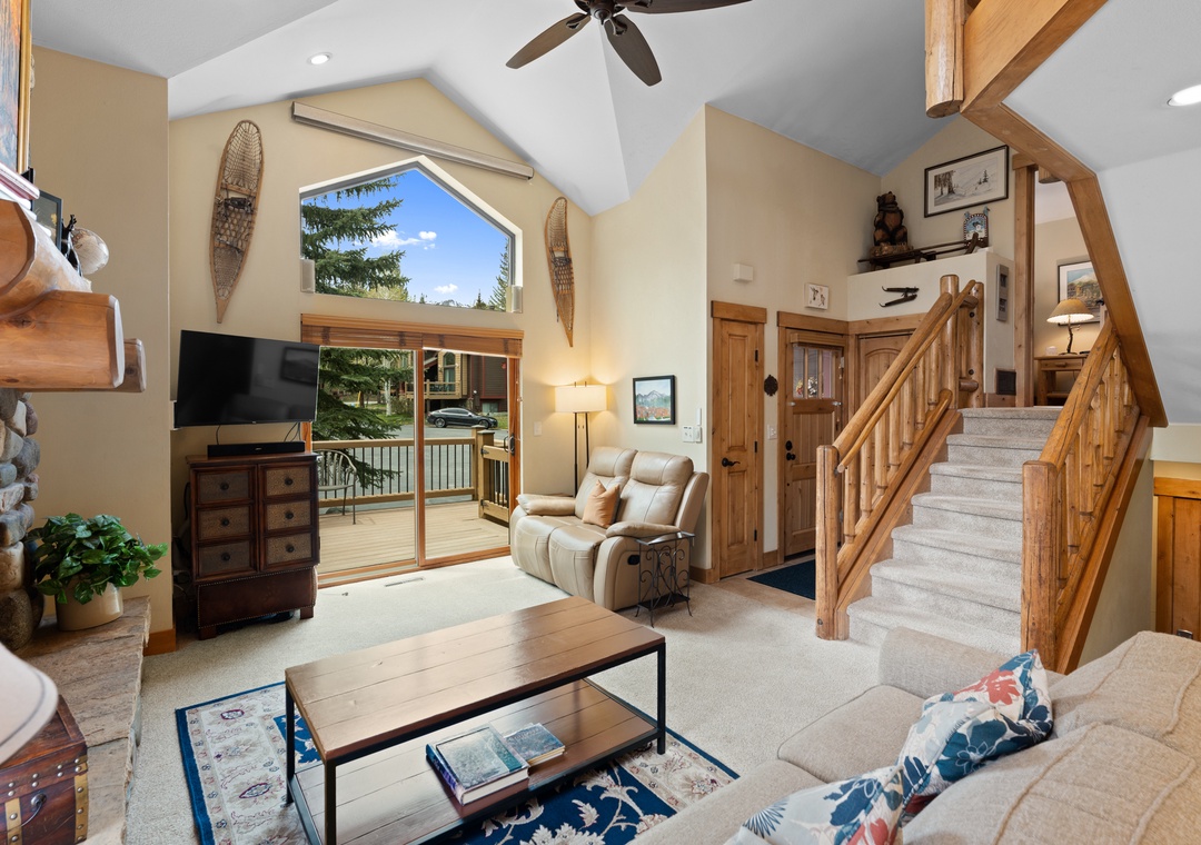 Sink into your cozy recliner and watch the trees sway outside your private balcony. This inviting living room features vaulted ceilings, warm wood accents, and mountain charm throughout.